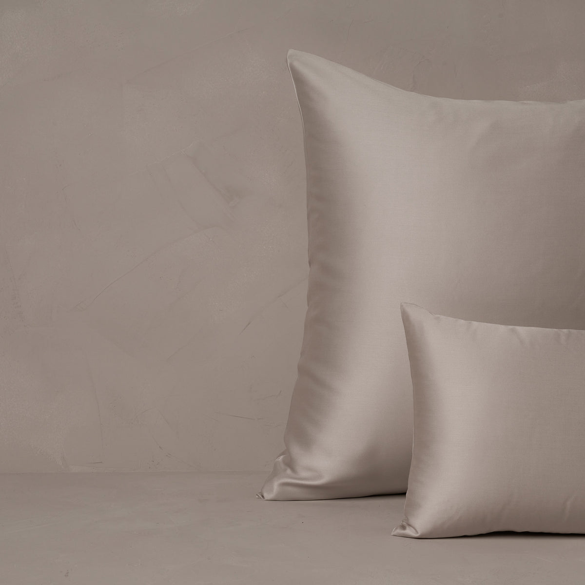 An image of a small boudoir or travel size pillow stacked in front of a large euro size pillow. The pillow cases are made in Italy of LETTO Woodland Silk fabric in color gray, a smooth and silky beechwood modal. data-image-id=
