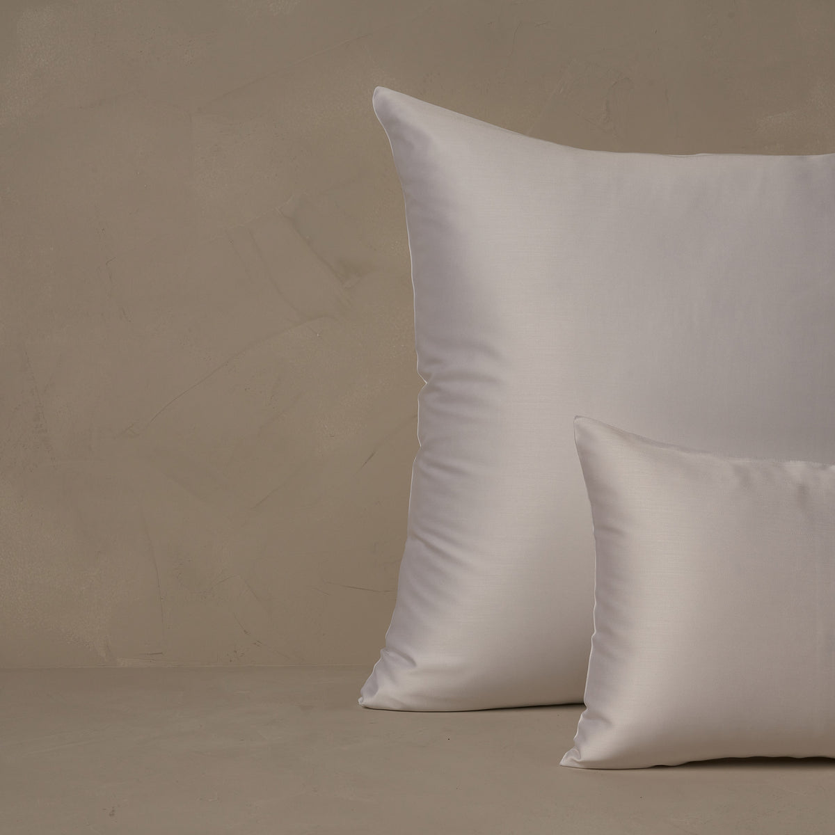 An image of a small boudoir or travel size pillow stacked in front of a large euro size pillow. The pillow cases are made in Italy of LETTO Woodland Silk fabric in color white, a smooth and silky beechwood modal. data-image-id=