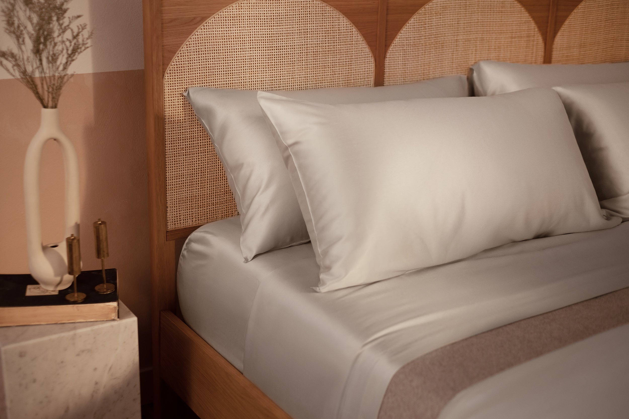 A close up picture of a bed made with LETTO Woodland Silk beechwood modal sheets and pillowcases in color gray.